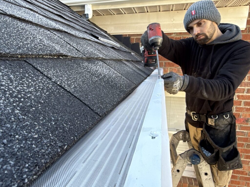 LeafFilter technician installing a new LeafFilter gutter guard system onto residential gutters