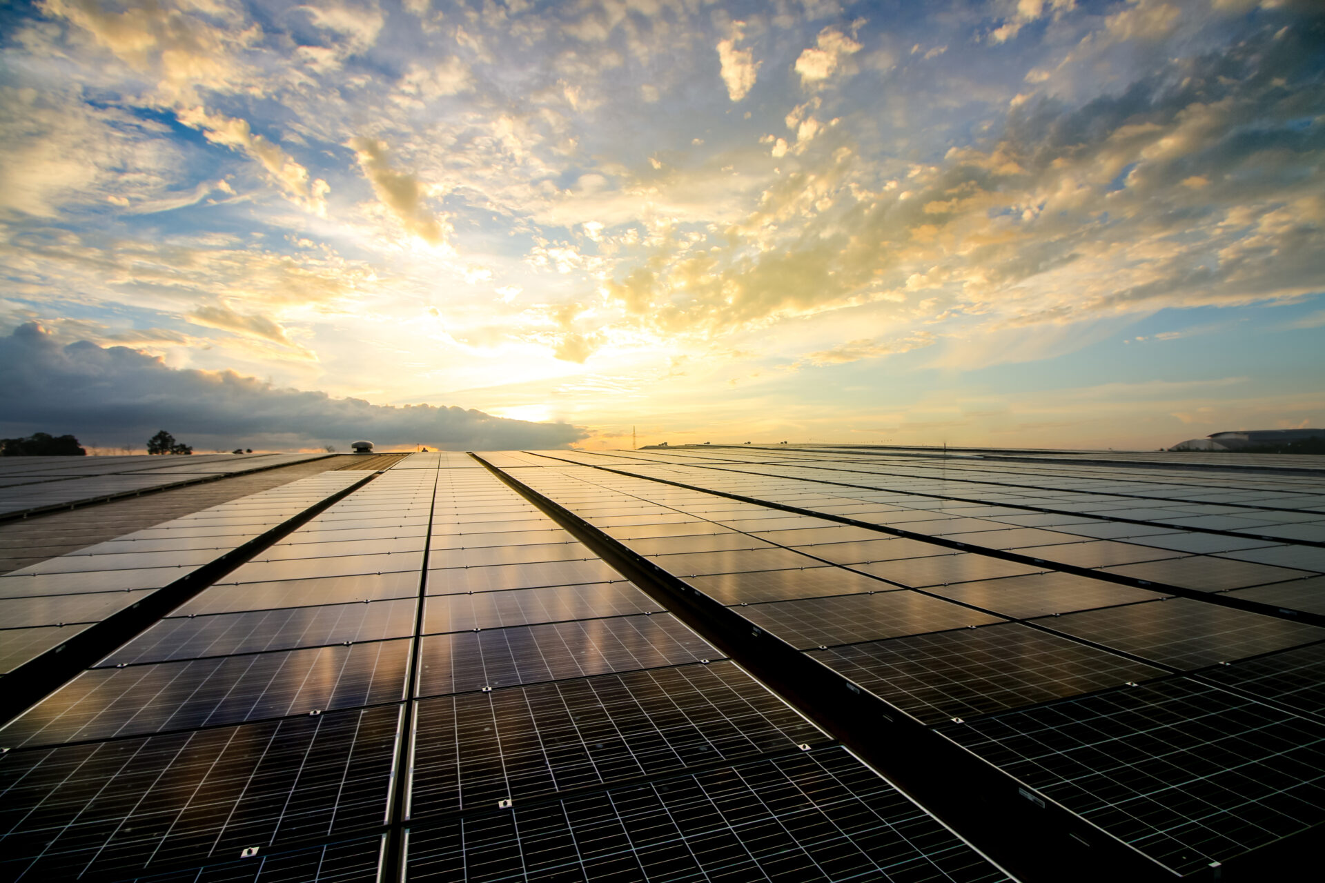 Solar panels on a roof in front of a sunset