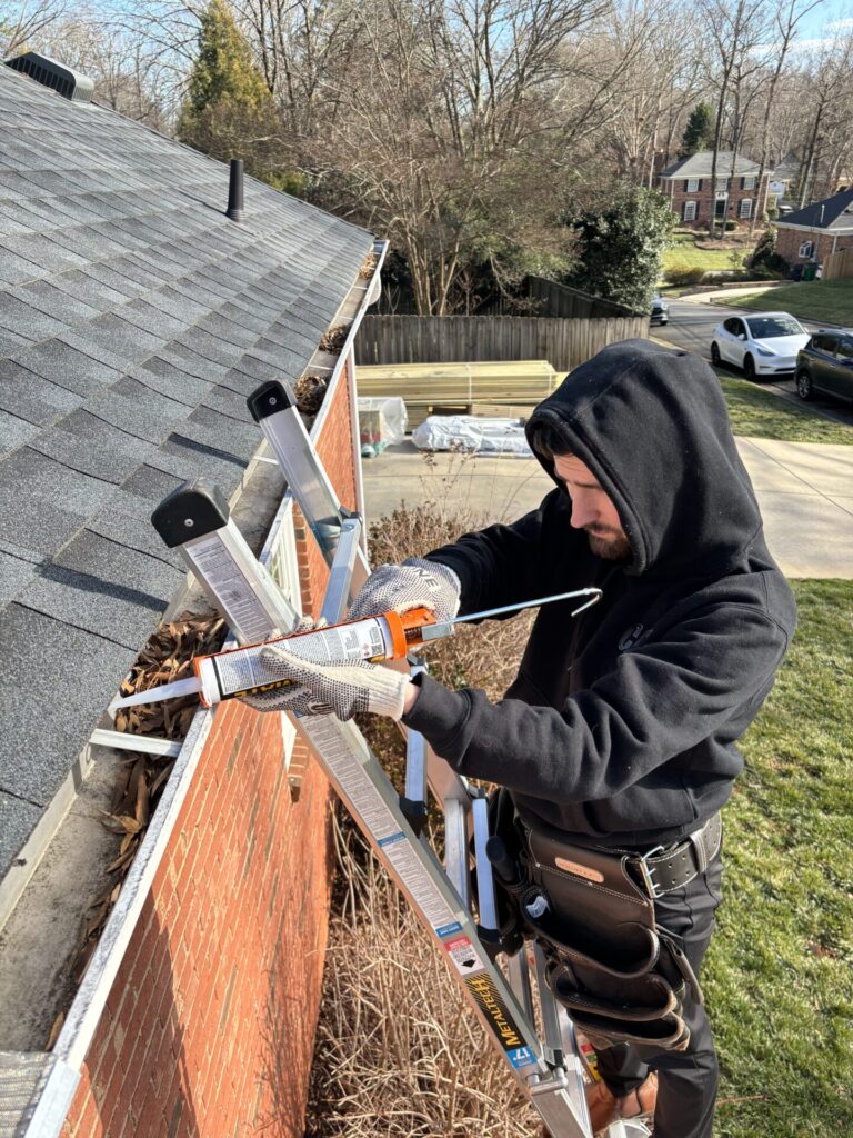 Gutter guard installer working on a residential gutter system
