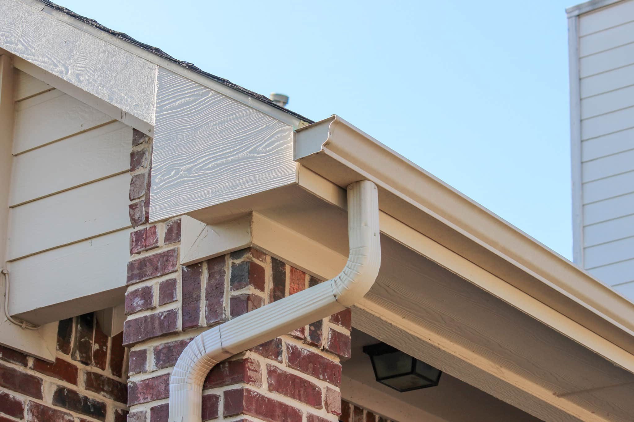Side of a brick house showing the gutter
