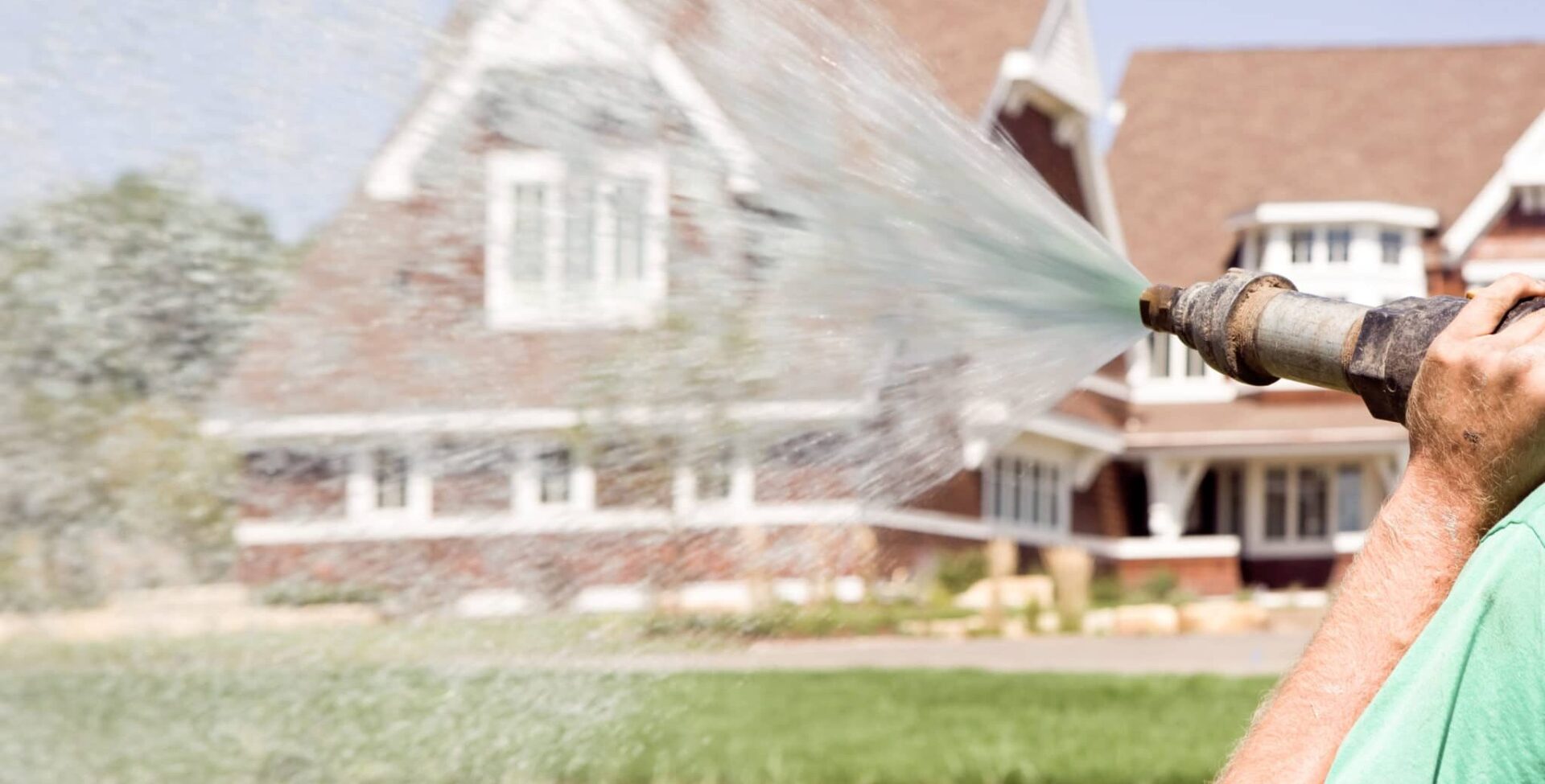 A landscaper hydroseeding a yard