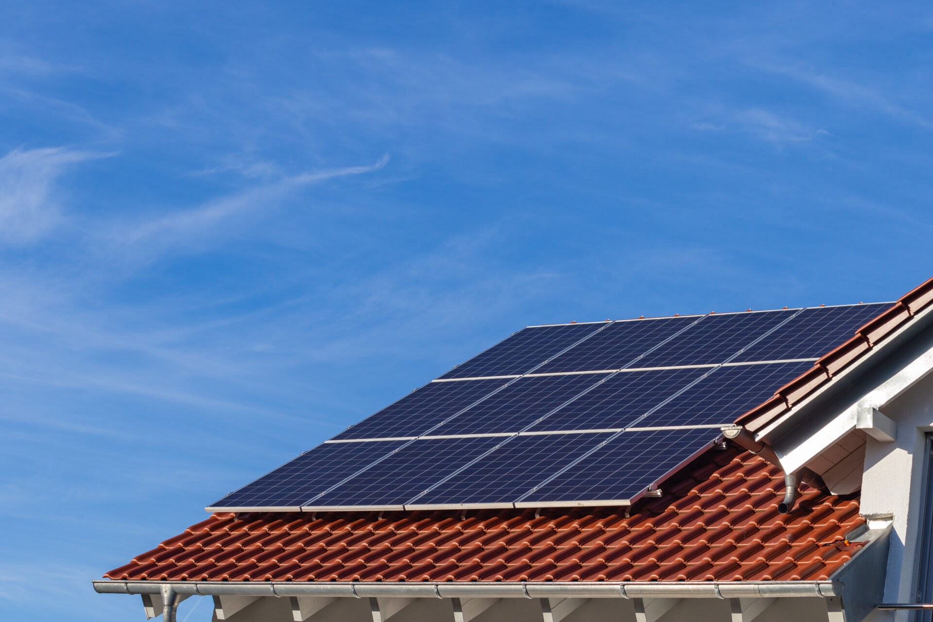 solar panels on a house roof with clay tiles