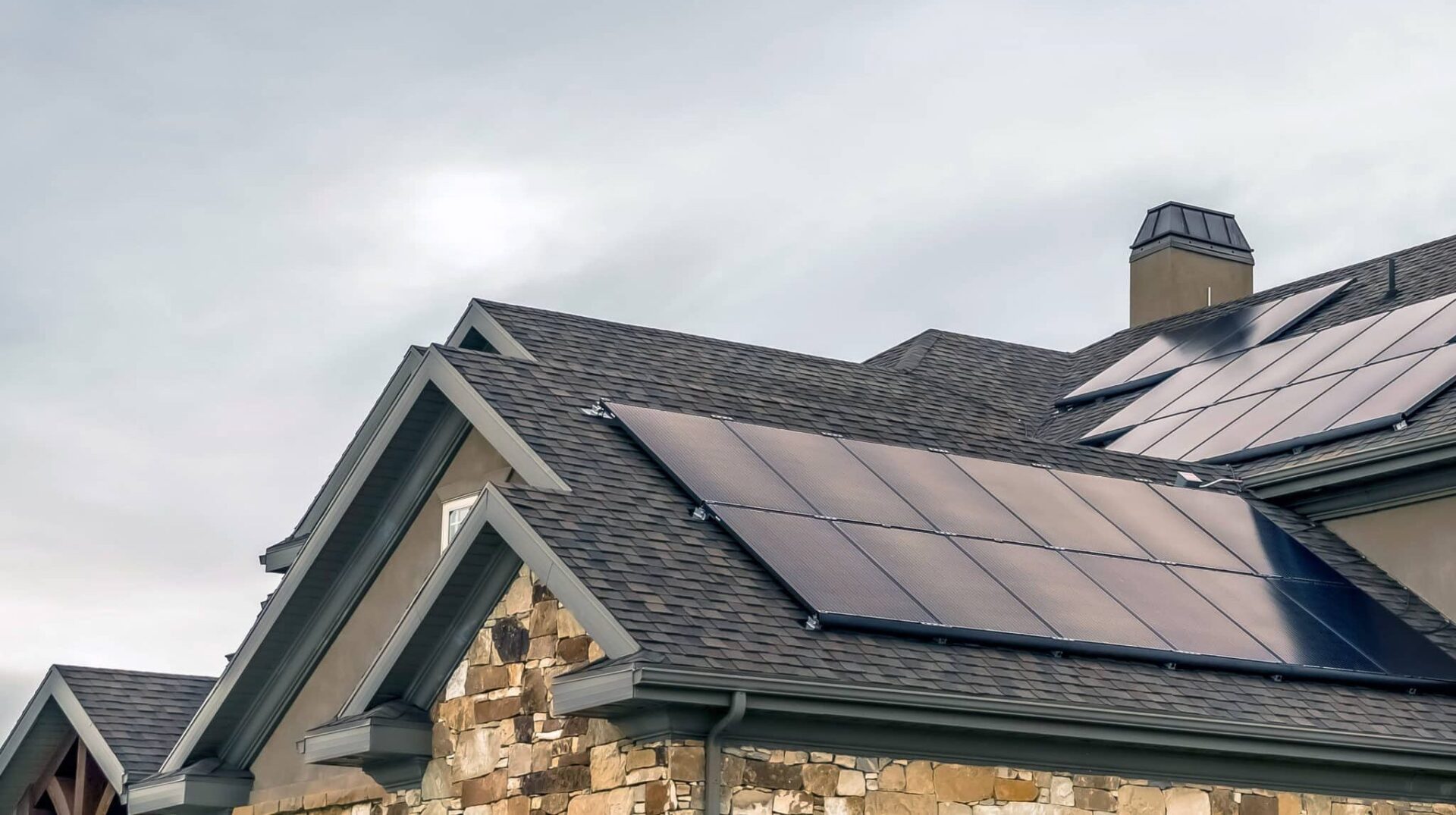 picture of a nice house with solar panels on the roof under a grey sky