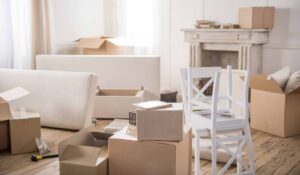 Cardboard boxes, furniture and hammer with nails in empty room ready for a move in Vermont