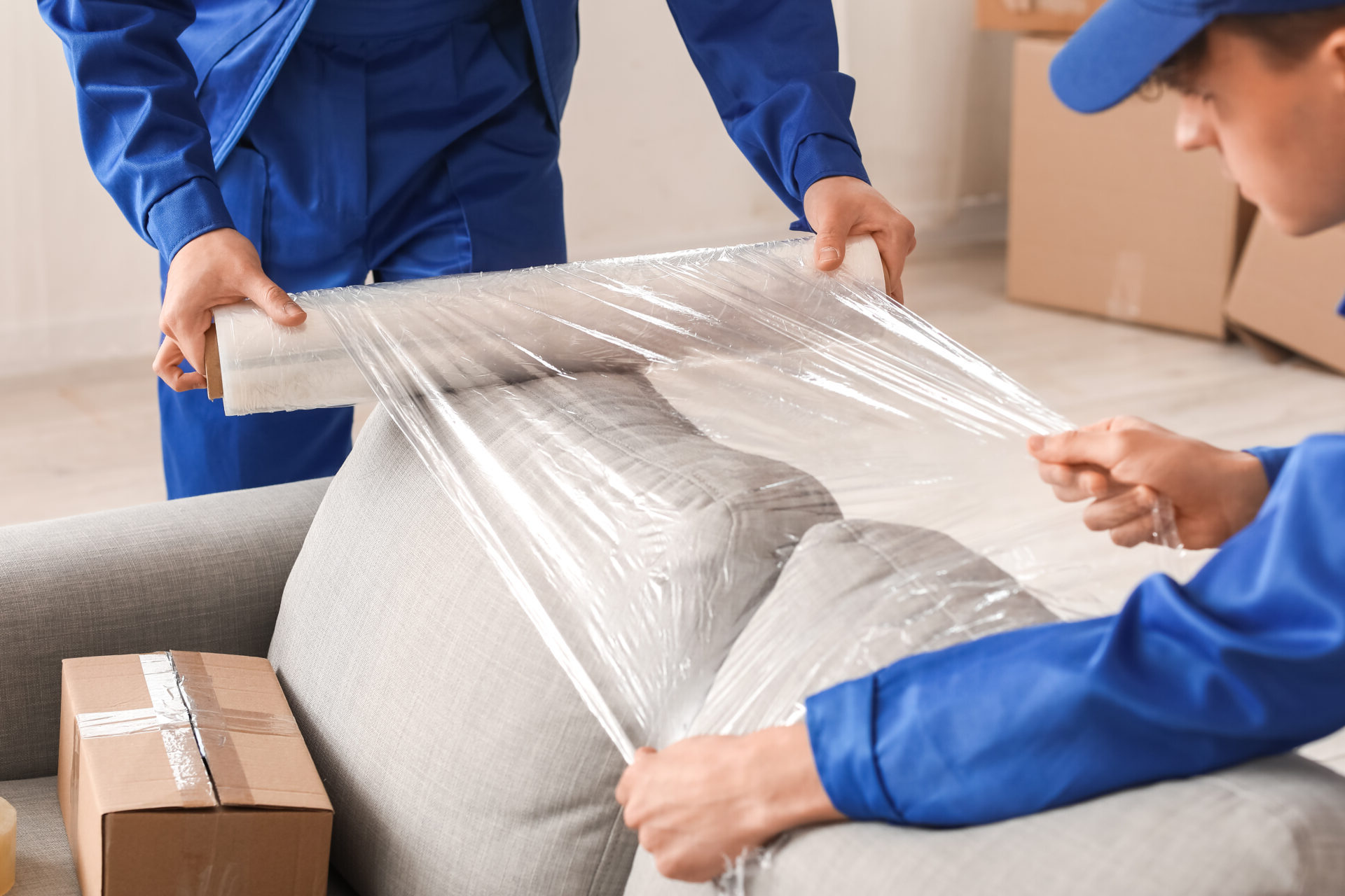 movers wrapping a sofa in stretch film