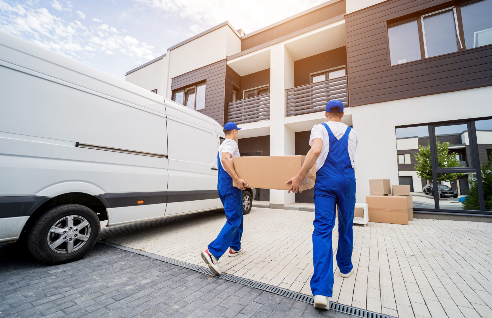 Two moving company workers unloading boxes and furniture
