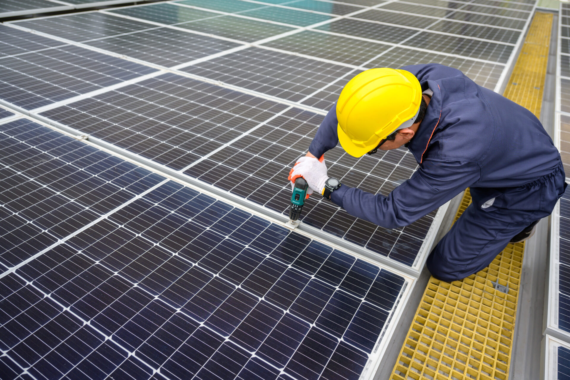 A solar power system engineer inspects solar panels on the roof