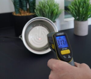 Infrared thermometer gun reading the temperature of a ceramic heat lamp at 317.3 degrees Fahrenheit