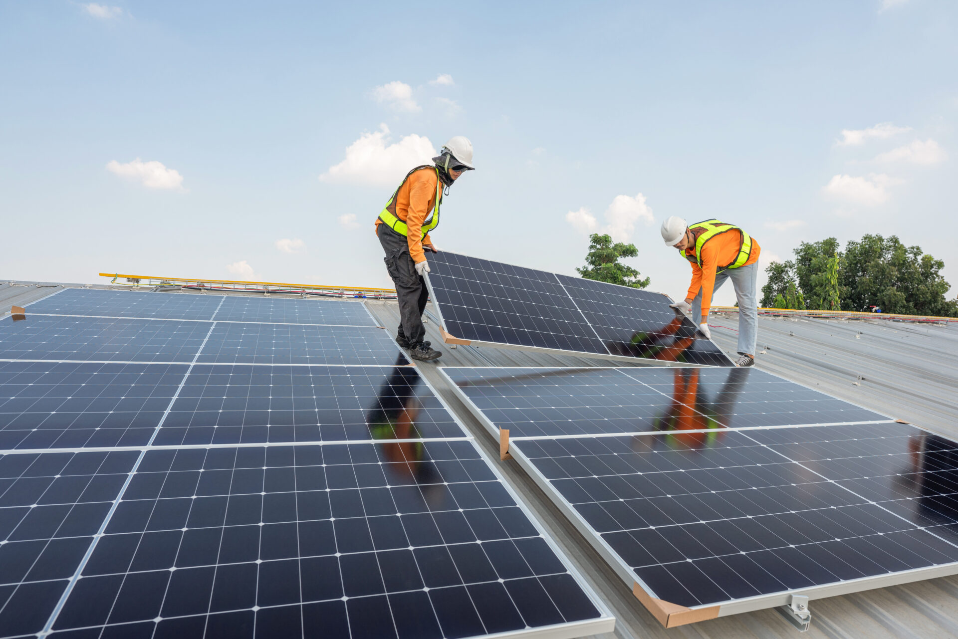 workers installing solar panels on a rooftop