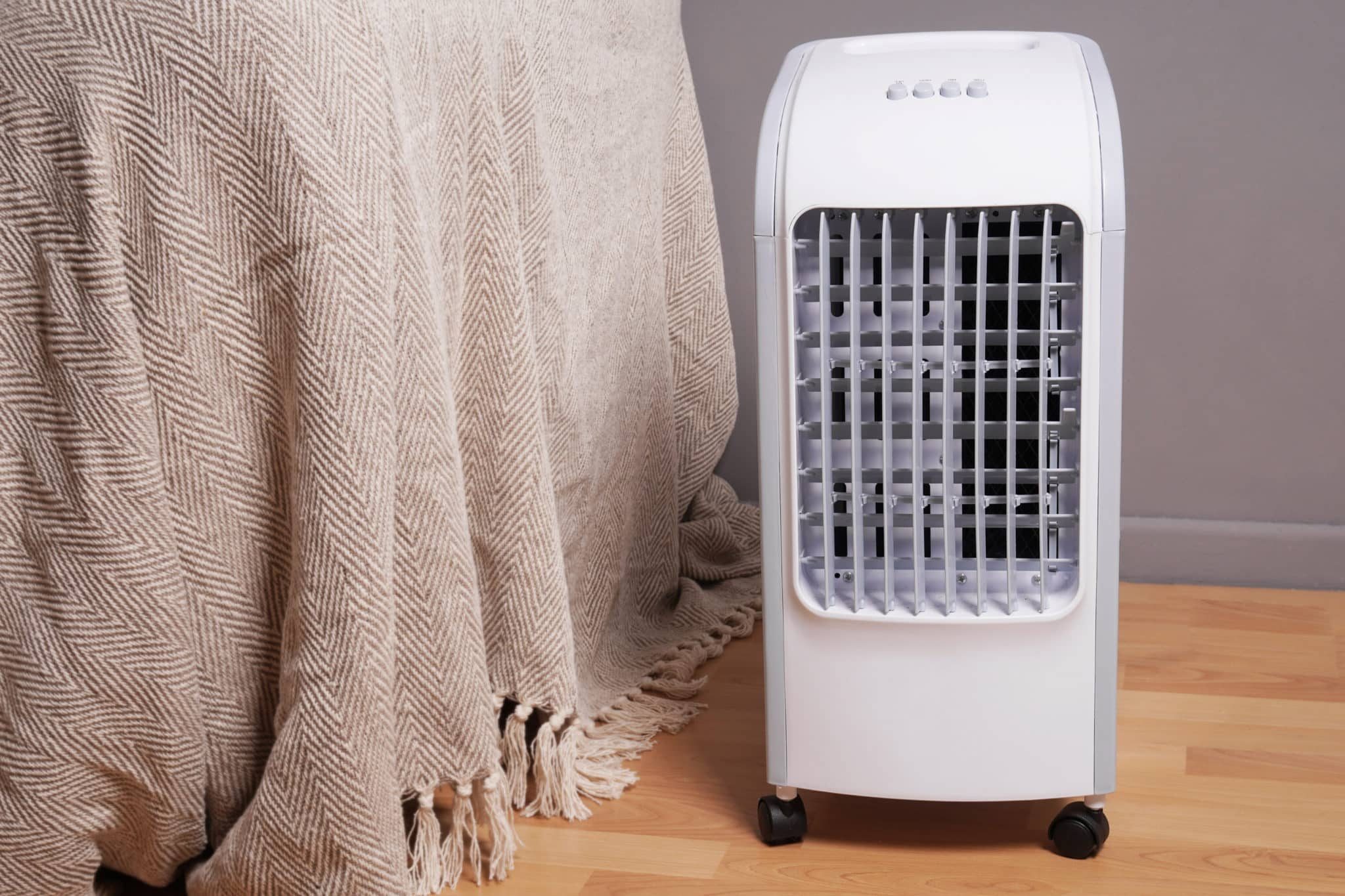 Portable air conditioner sitting beside a bed