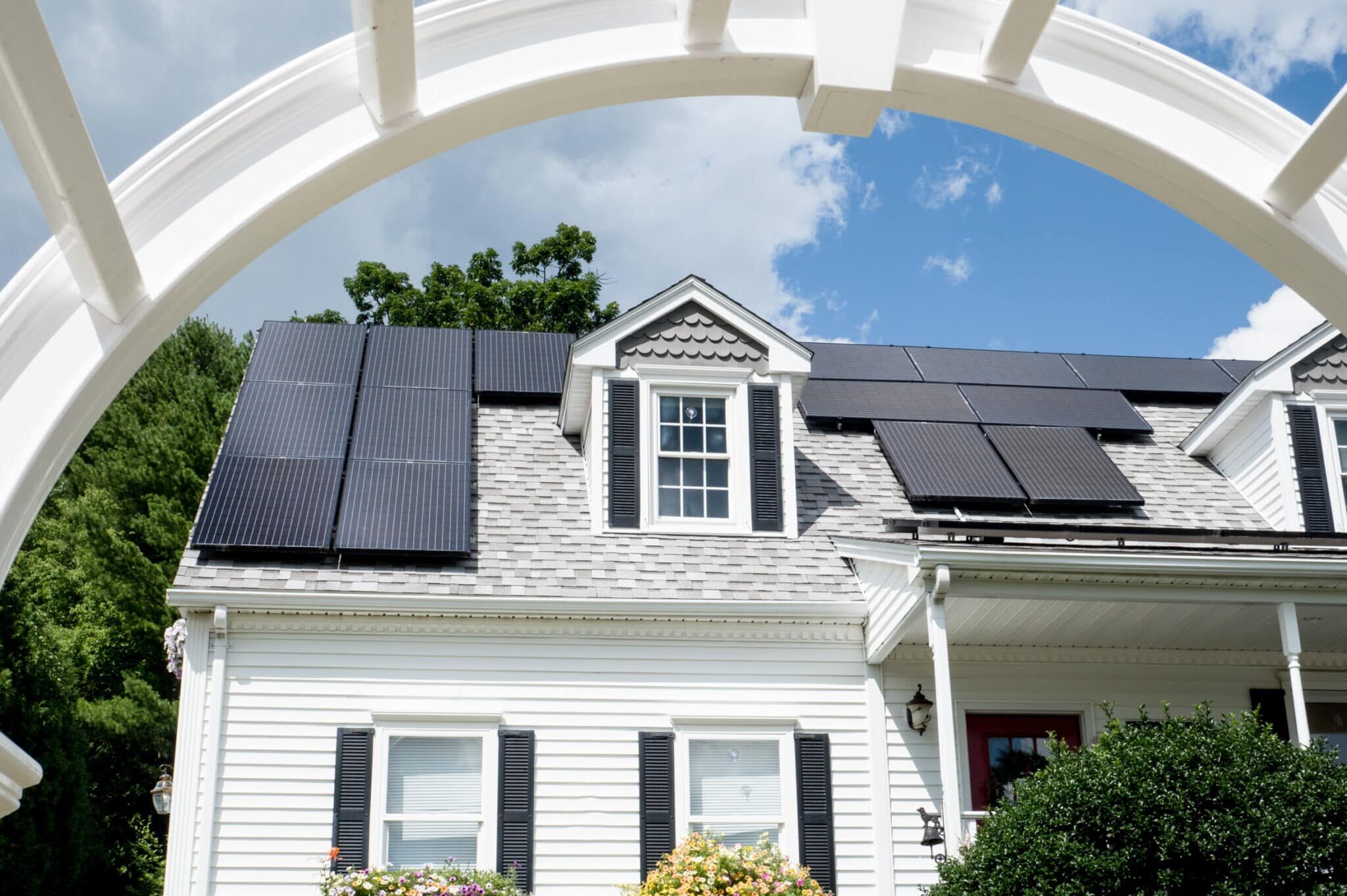 Solar panel installation on a nice cape cod house with sunny blue skies in the background