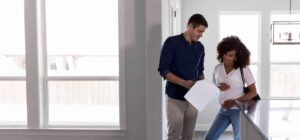 a man and a woman standing in a new house looking at their final walkthrough checklist