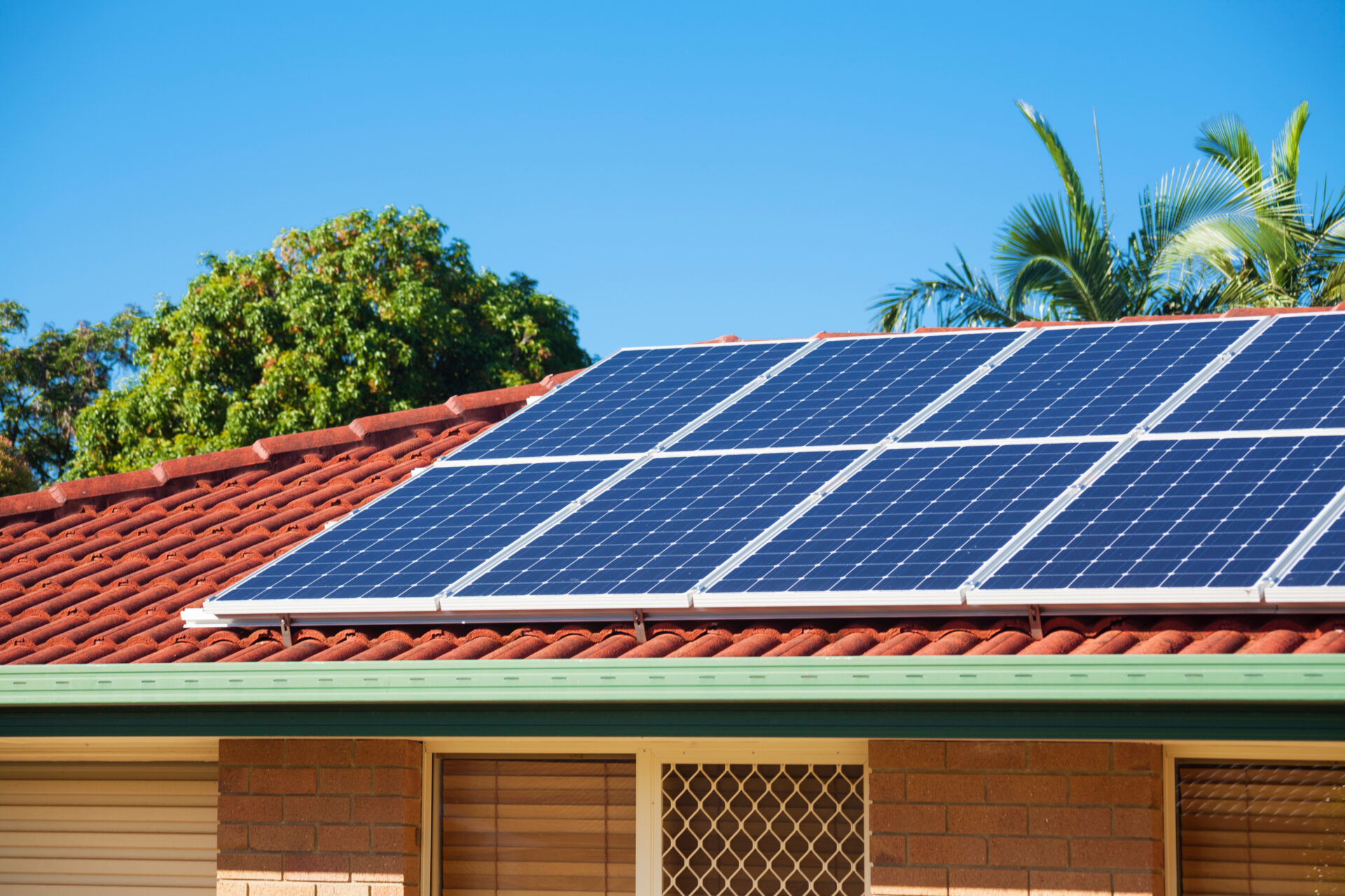 solar panels installed on a house roof with clay tiles