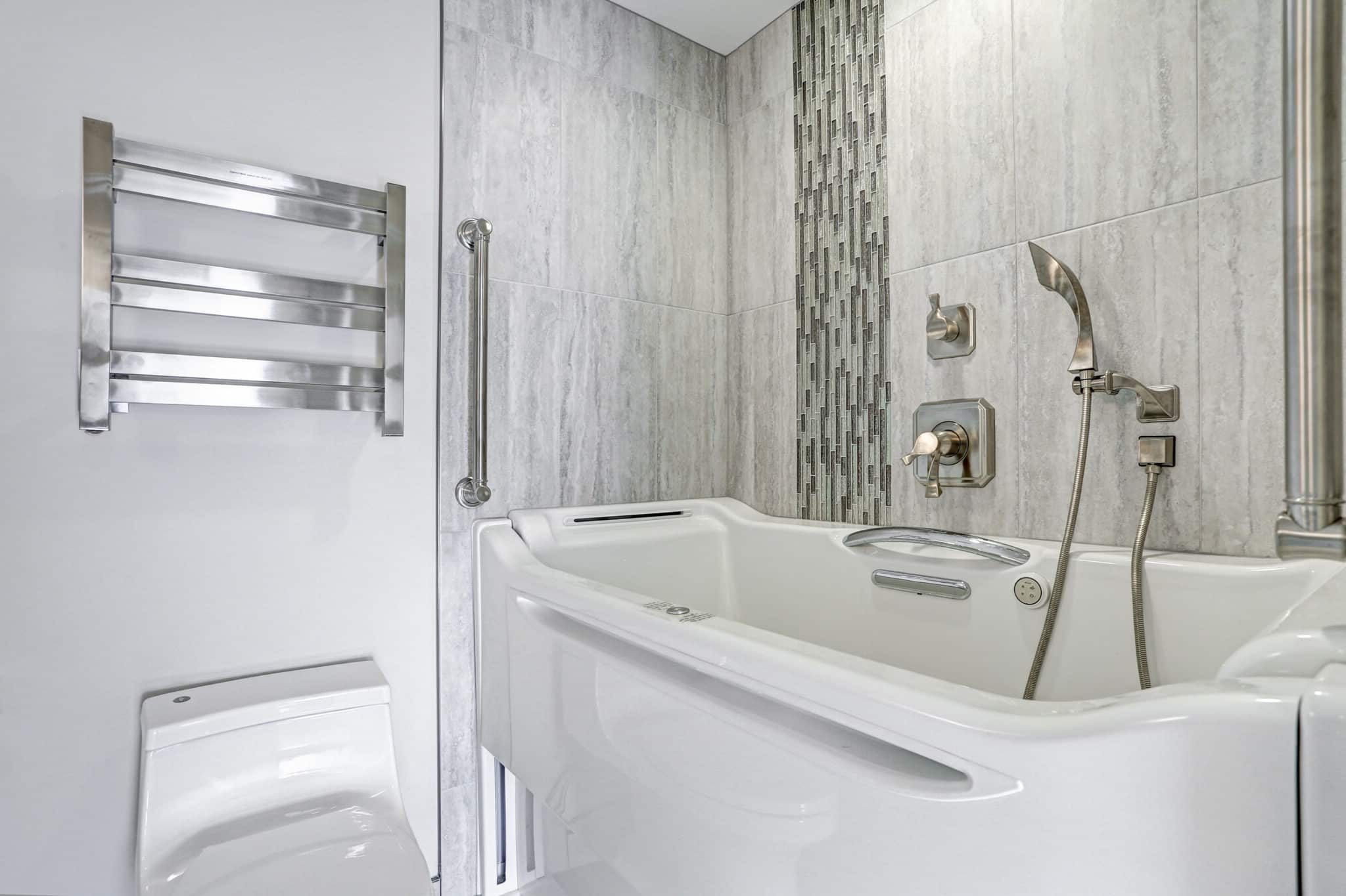 Contemporary bathroom design boasts a luxury hot tub Walk-in Bathtub flanked by subway tiled interior accented with wide glass mosaic tiled vertical stripe