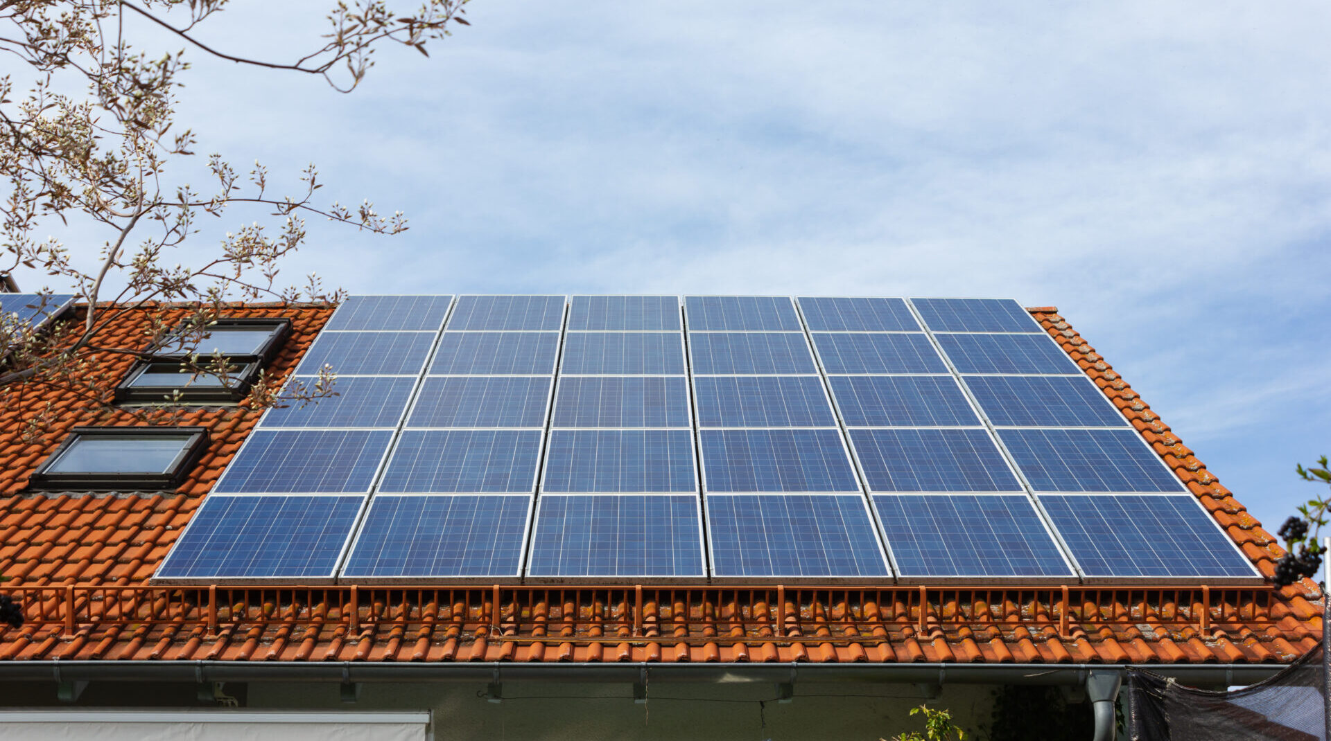 house with solar panels on the roof on a cloudy day