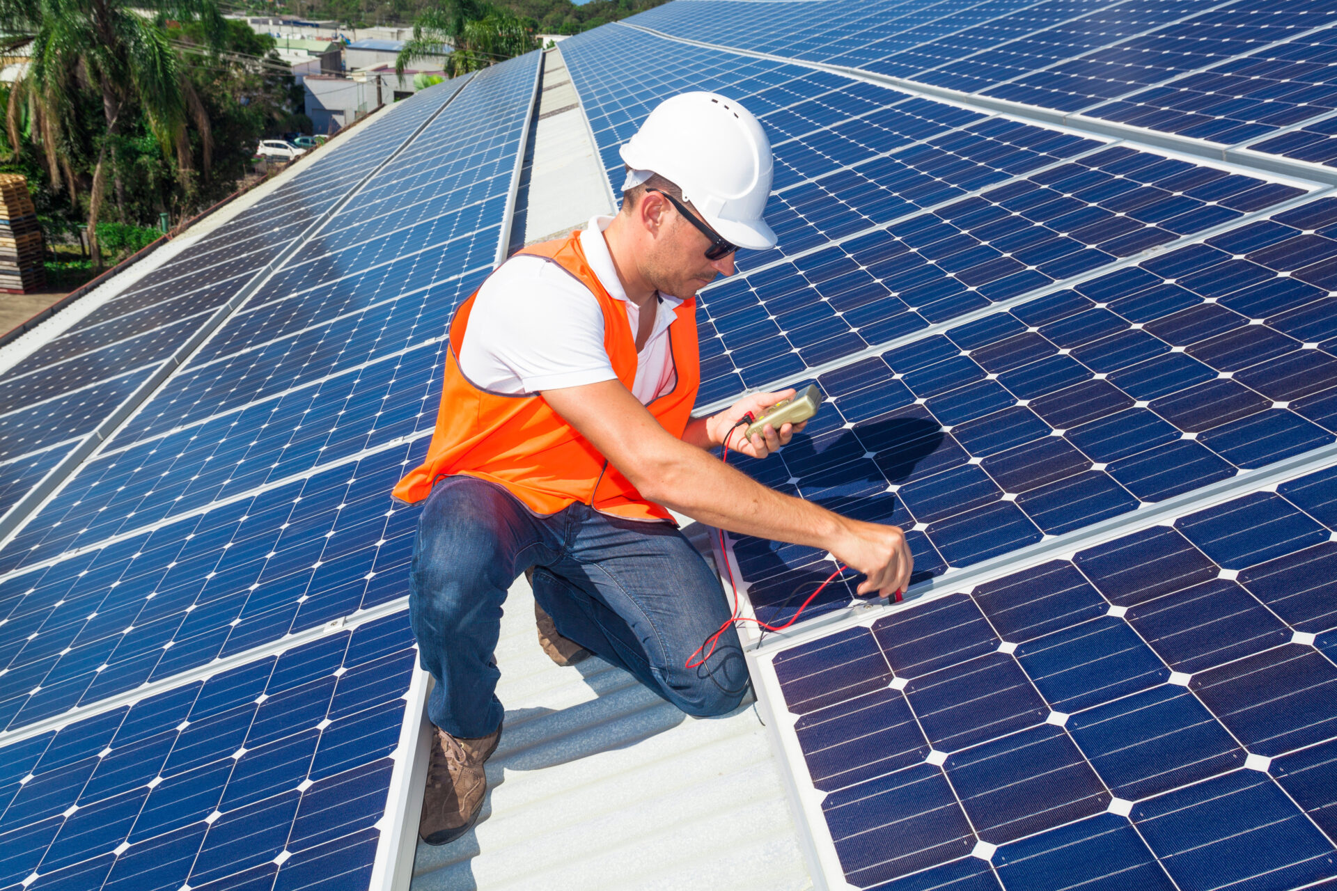 Young technician checking solar panels on factory roof