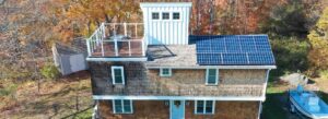 rhode island home with solar panels and a rooftop patio