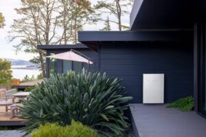 tesla powerwall battery on the exterior wall of a modern home