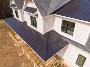 A house with a standing seam metal roof in the final steps of the construction process
