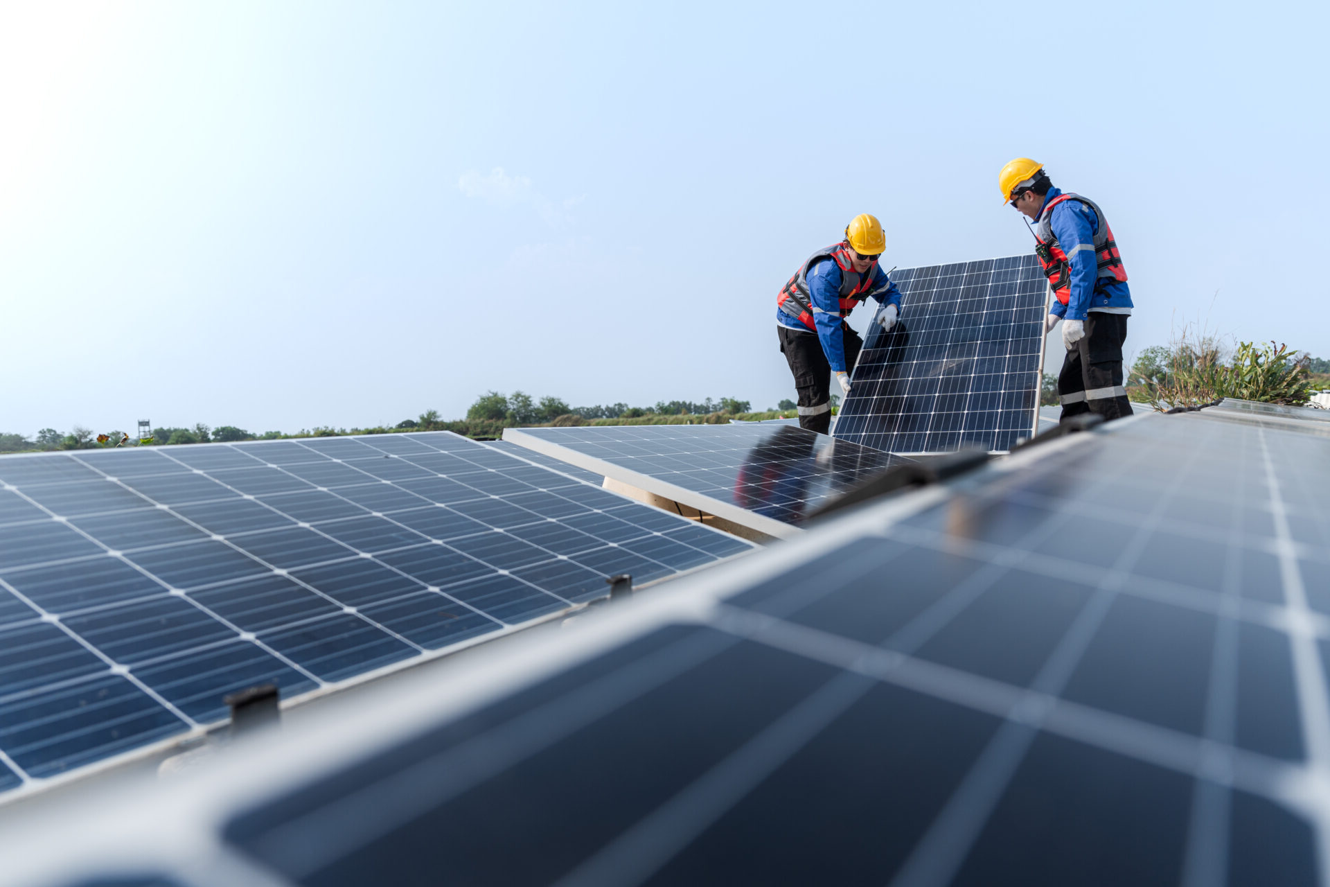 electricians installing solar panels on roof