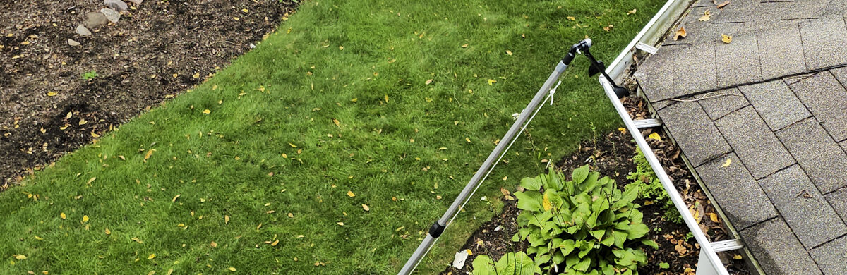 A man cleaning gutters with a tool