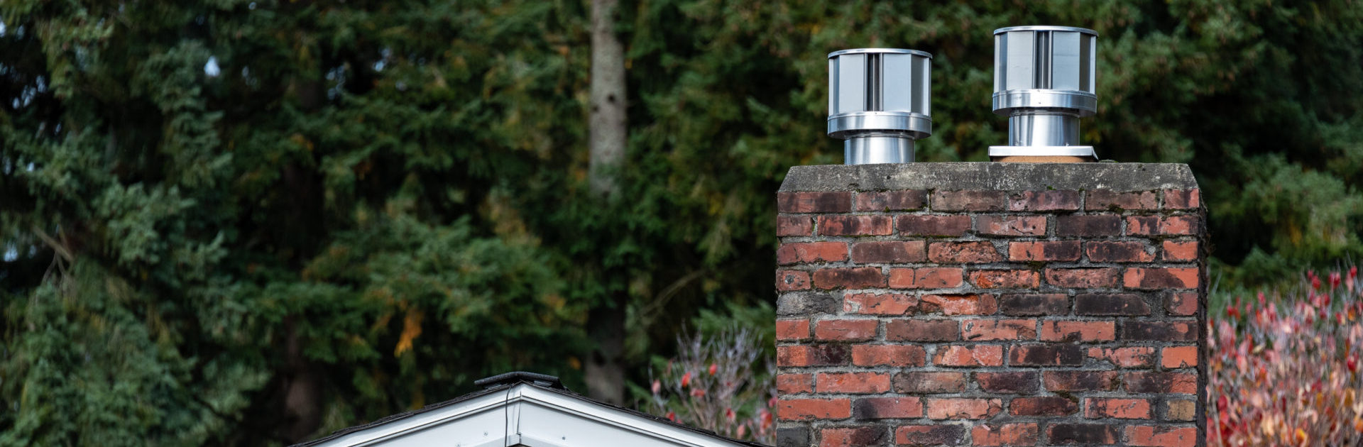 Exterior wall of suburban house, old brick chimney with chimney vents