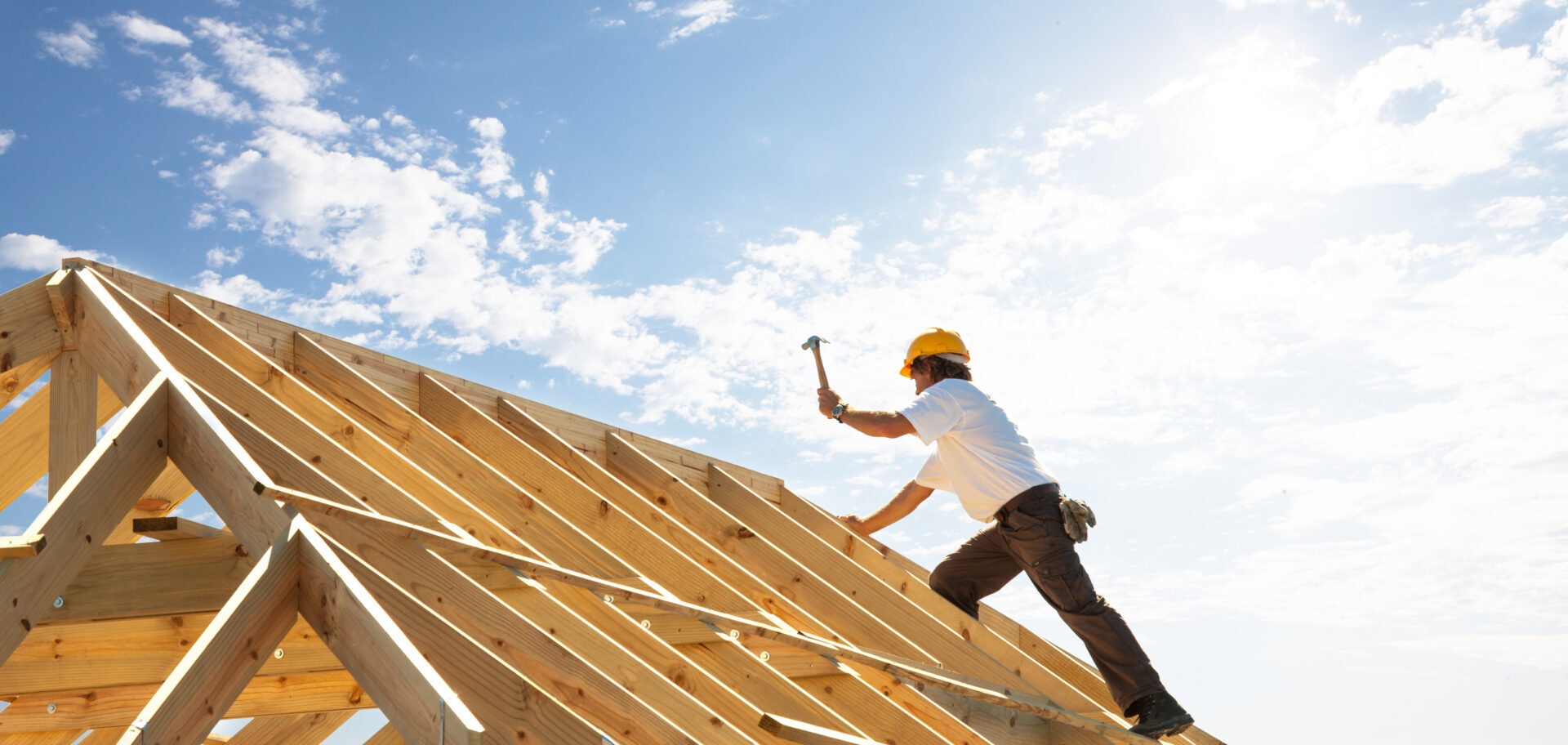 a man building a roof on a bright and sunny day