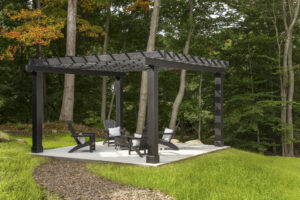 Newly finished covered concrete patio in a lush green backyard.