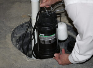 man installing a sump pump in a basement