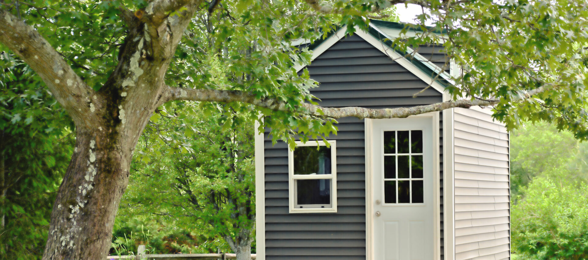 A tiny gray house on wheels