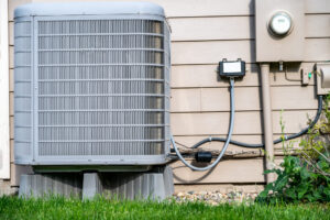 Outdoor residential air conditioner on an elevated pad.