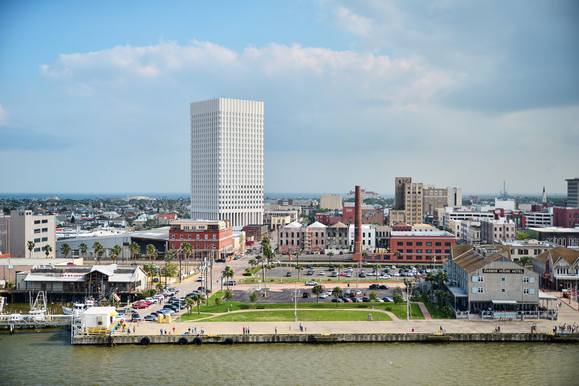 Galveston, Texas/USA: Coastal cityscape with a modern high-rise, historic brick buildings, and a waterfront promenade.