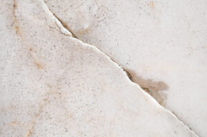 Close-up on a cracked slab foundation with leaking water