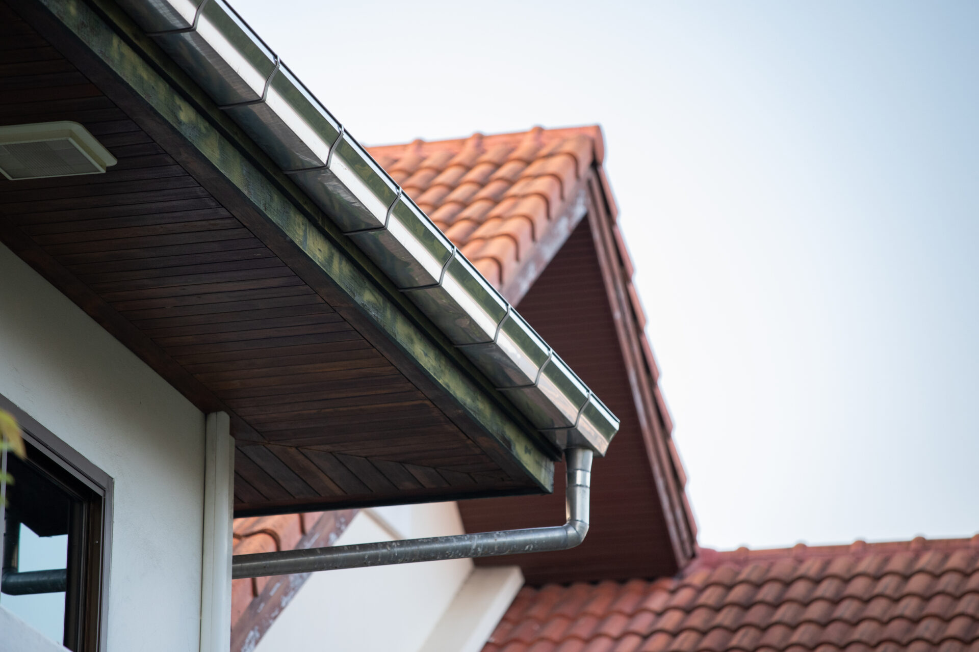 Stainless steel rain gutter on top of roof.